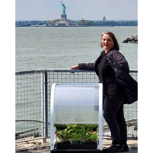Wendy standing next to a pPod with the Statue of Liberty in the background